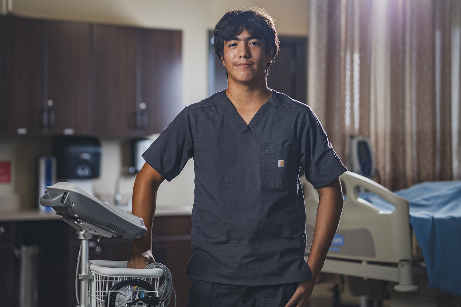 Med student standing in hospital room.